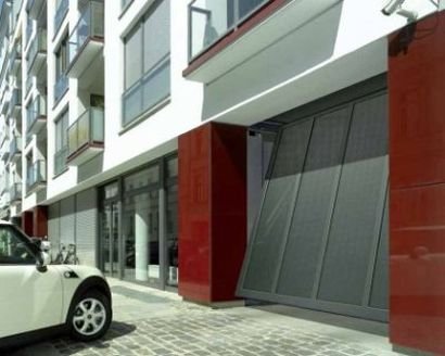 Puerta basculante metálica en garaje comunitario de edificio residencial